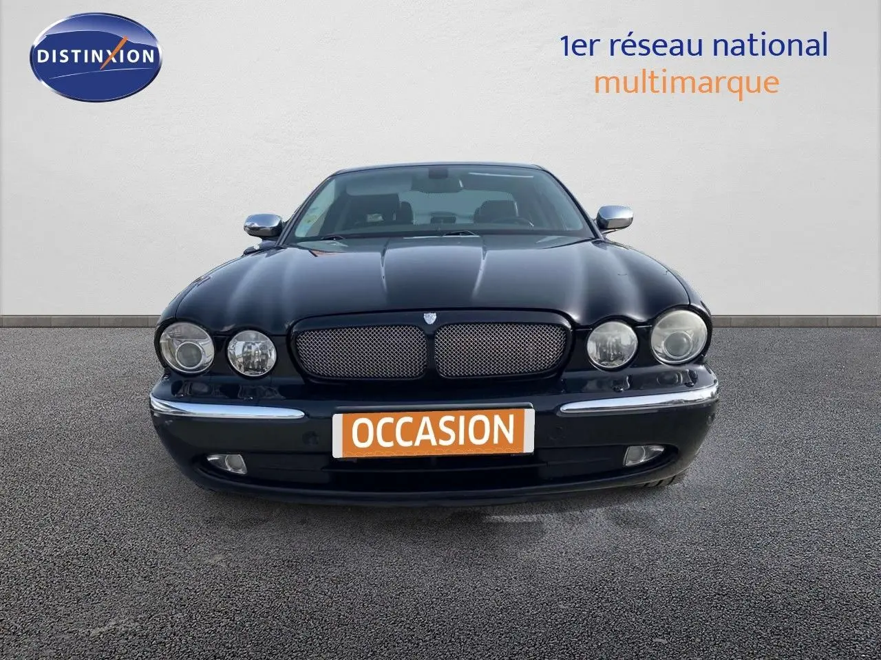 Vue frontale d'une Jaguar XJ6 noire de 2006 avec calandre distinctive et phares ronds doubles.
