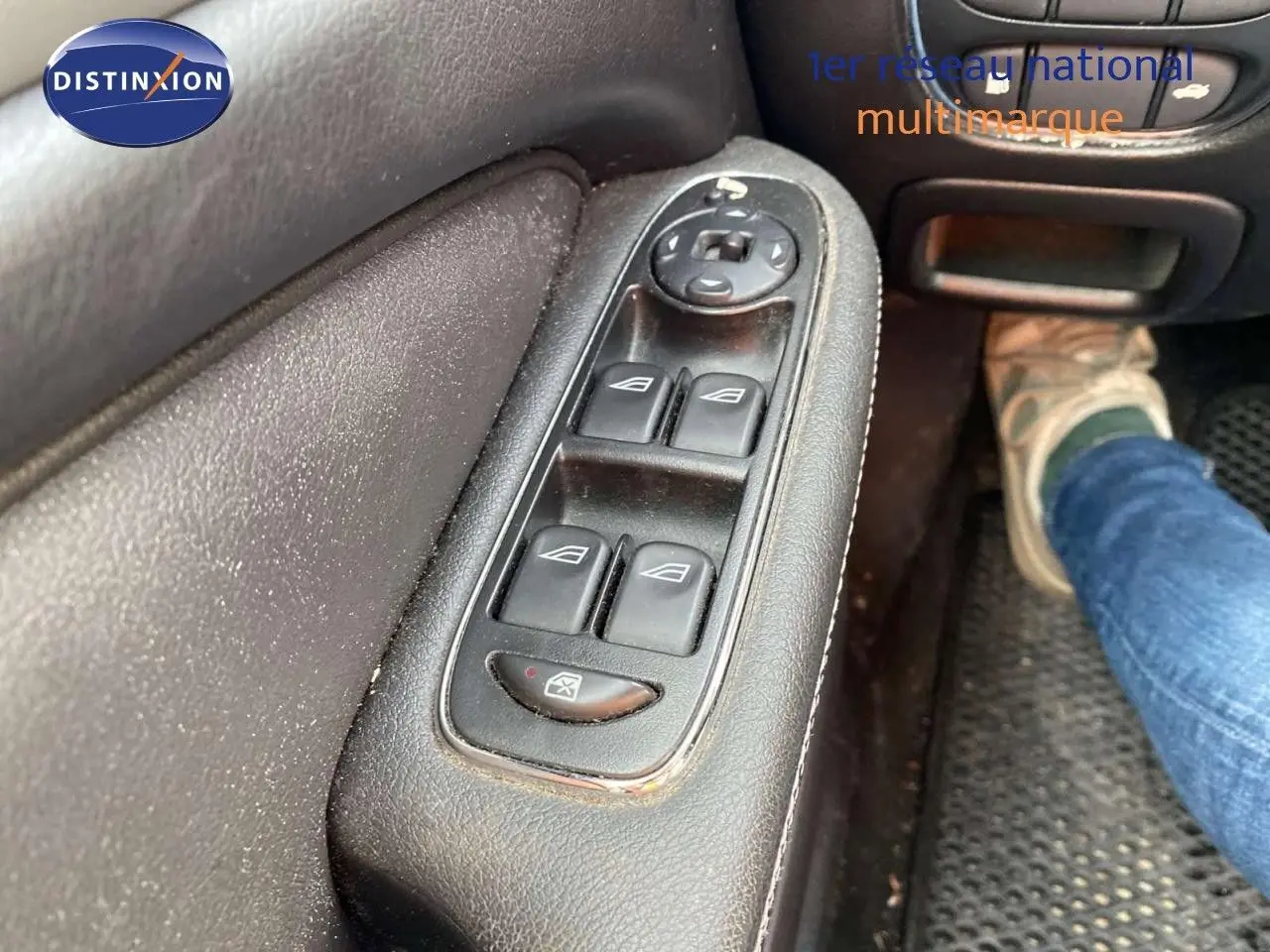 Gros plan sur les commandes des vitres électriques côté gauche d'une Jaguar XJ6 noire de 2006, intérieur cuir noir.
