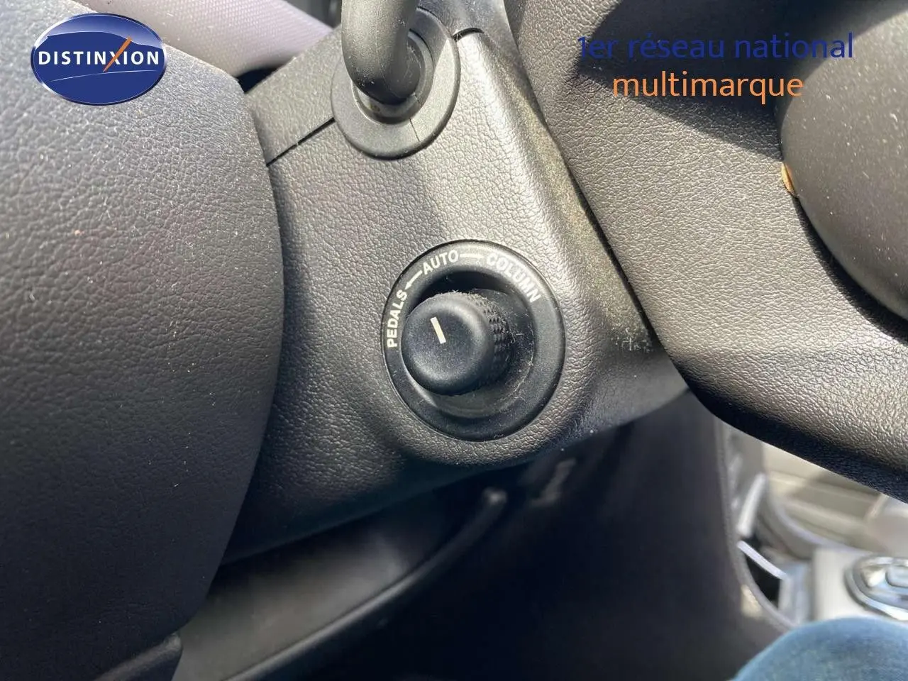 Gros plan sur le bouton de réglage des pédales dans l'habitacle noir d'une Jaguar XJ6 2.7 V6 Biturbo Executive.