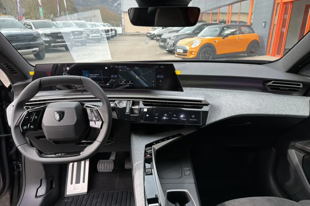 Vue intérieure avant du Peugeot 3008 Hybrid 145 GT Alcantara, tableau de bord moderne avec volant cuir et écran large.
