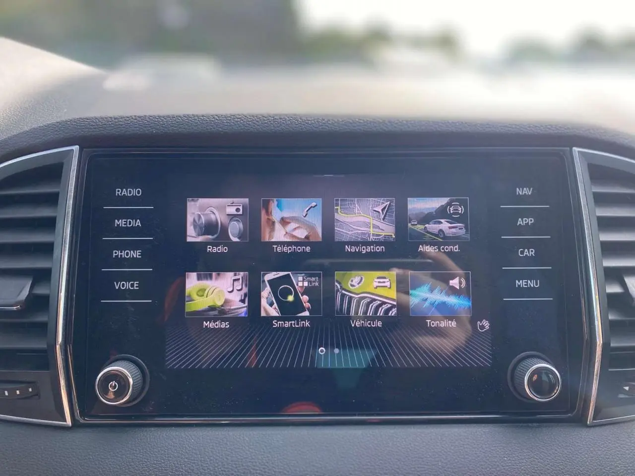 Écran tactile central du Skoda Karoq 2021 affichant les options radio, navigation, téléphone et aides à la conduite.