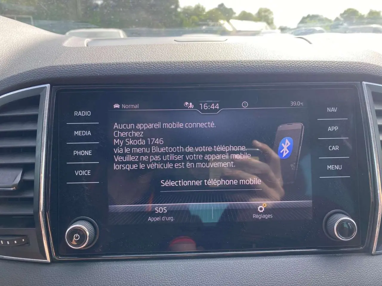Vue rapprochée de l'écran tactile central du Skoda Karoq vert foncé, affichant le menu Bluetooth et les commandes multimédia.