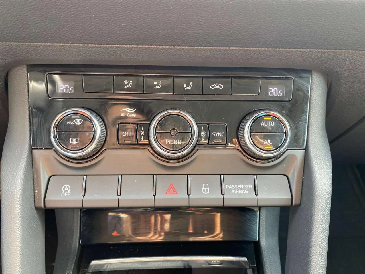 Gros plan sur la console centrale du Skoda Karoq vert foncé 2021, montrant les commandes de climatisation et les boutons de fonction.