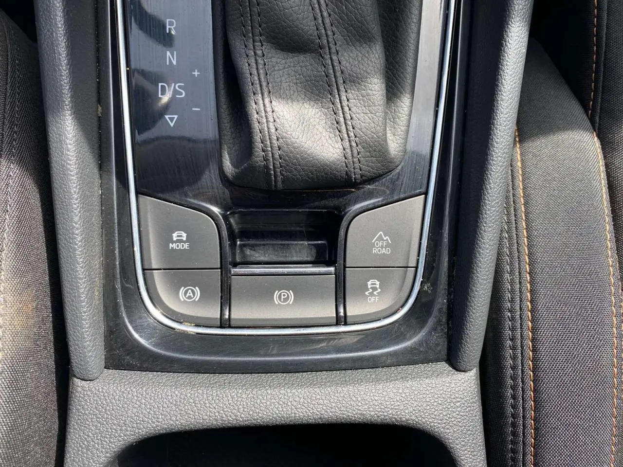 Gros plan sur la console centrale du Skoda Karoq vert foncé 2021, avec levier de vitesse automatique et boutons mode off-road.