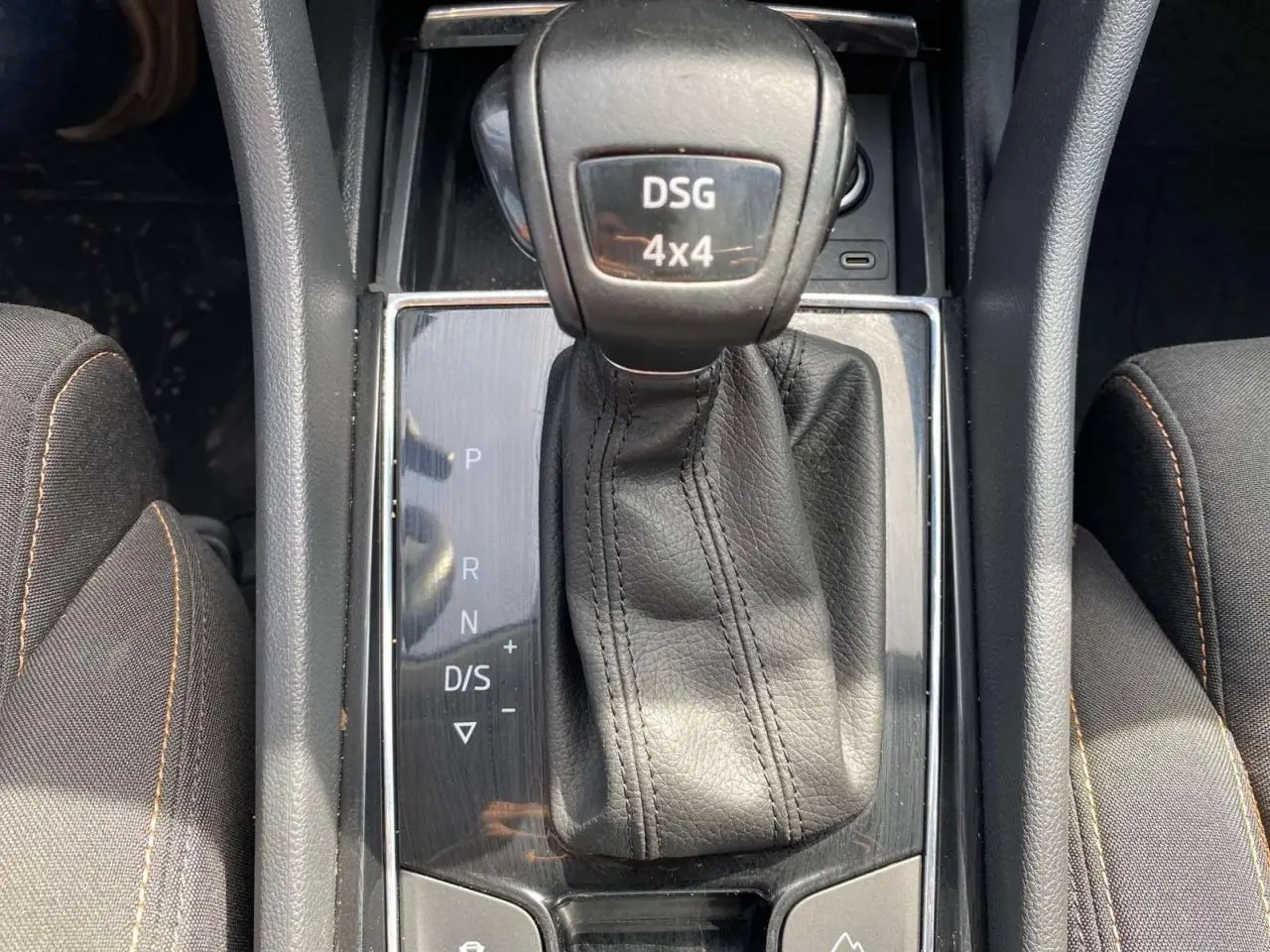 Gros plan sur le levier de vitesses DSG 4x4 noir du Skoda Karoq Scout 2021, entouré de sièges tissu gris foncé.