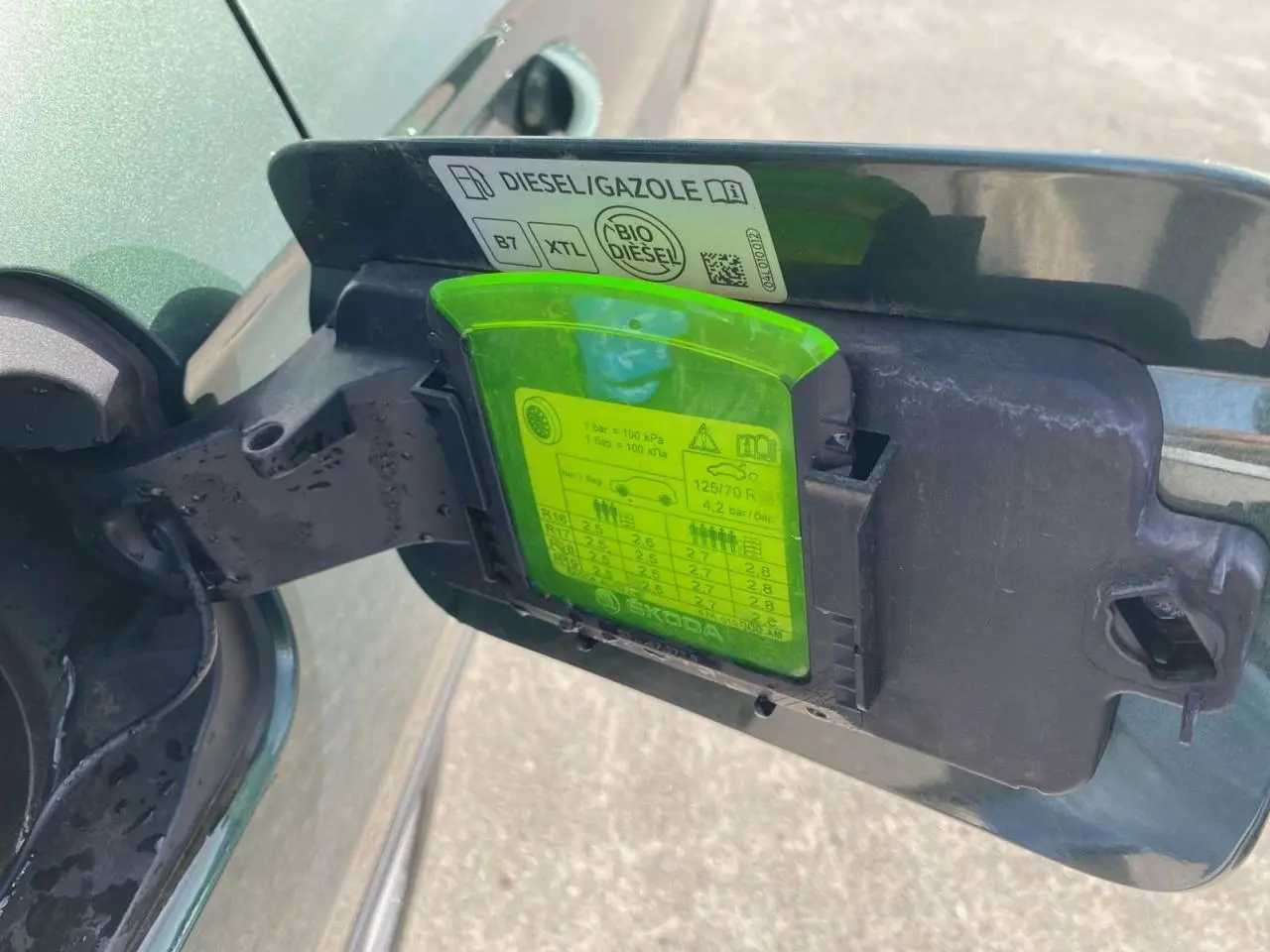 Bouchon de réservoir ouvert côté gauche d’un Skoda Karoq vert foncé 2.0 TDI 2021 avec étiquette diesel visible.