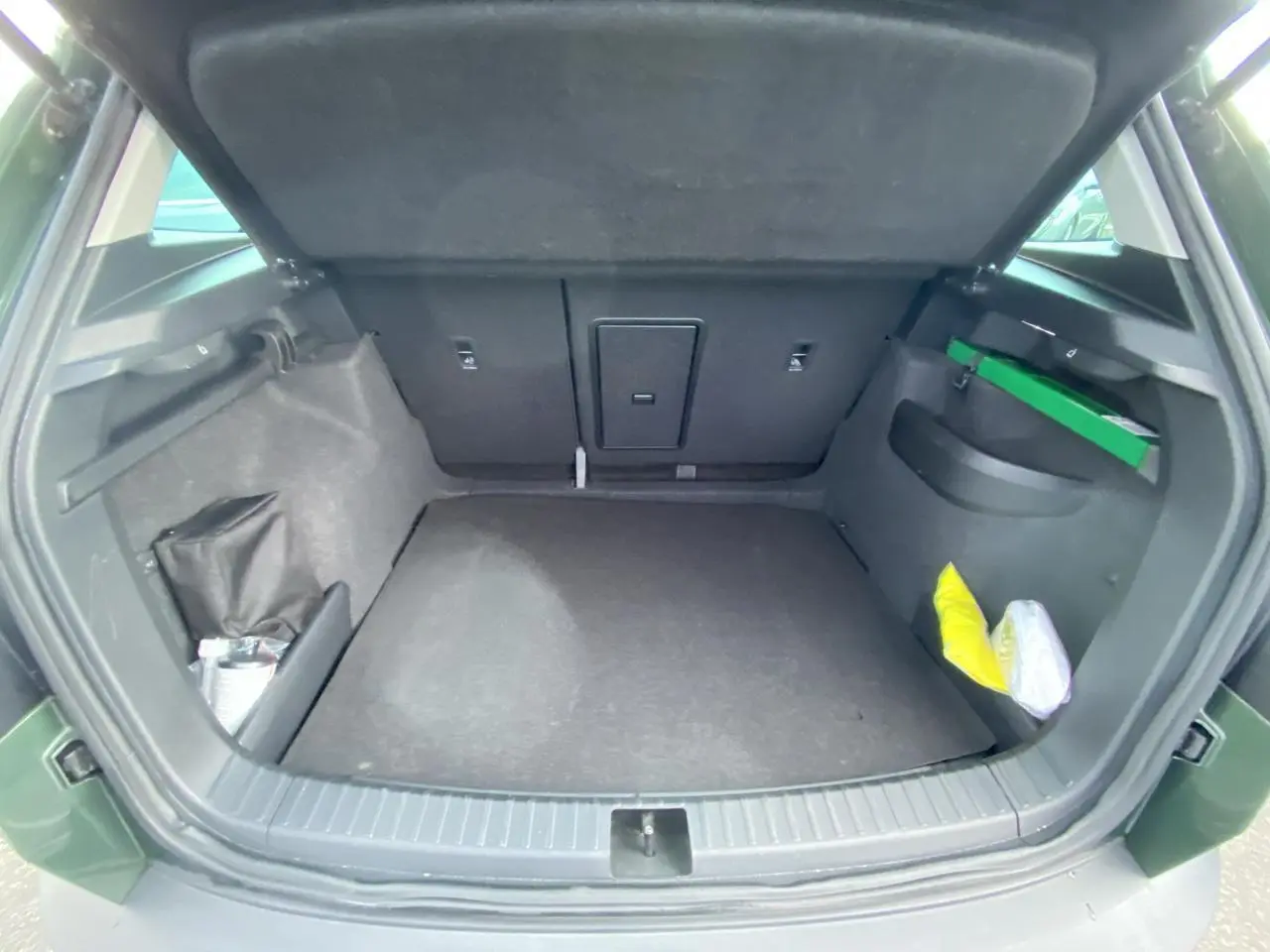 Coffre ouvert vu de l'arrière d'un Skoda Karoq Scout 2021 vert foncé, montrant un espace de chargement vide.
