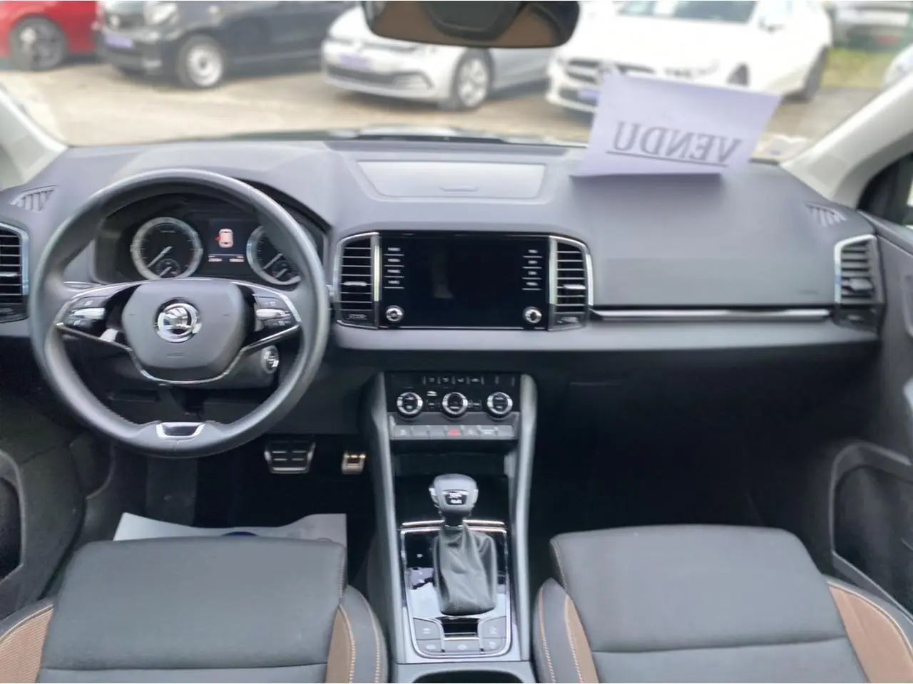 Vue intérieure frontale du tableau de bord et volant du Skoda Karoq 2021, finition Scout, avec console centrale et écran tactile.