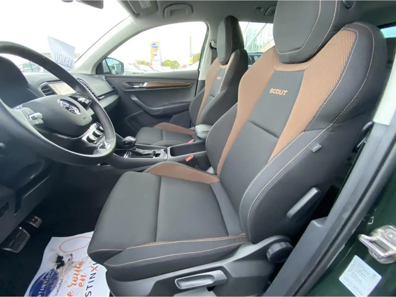 Vue intérieure côté conducteur du Skoda Karoq Scout 2021, sièges noirs et marron avec logo Scout brodé.