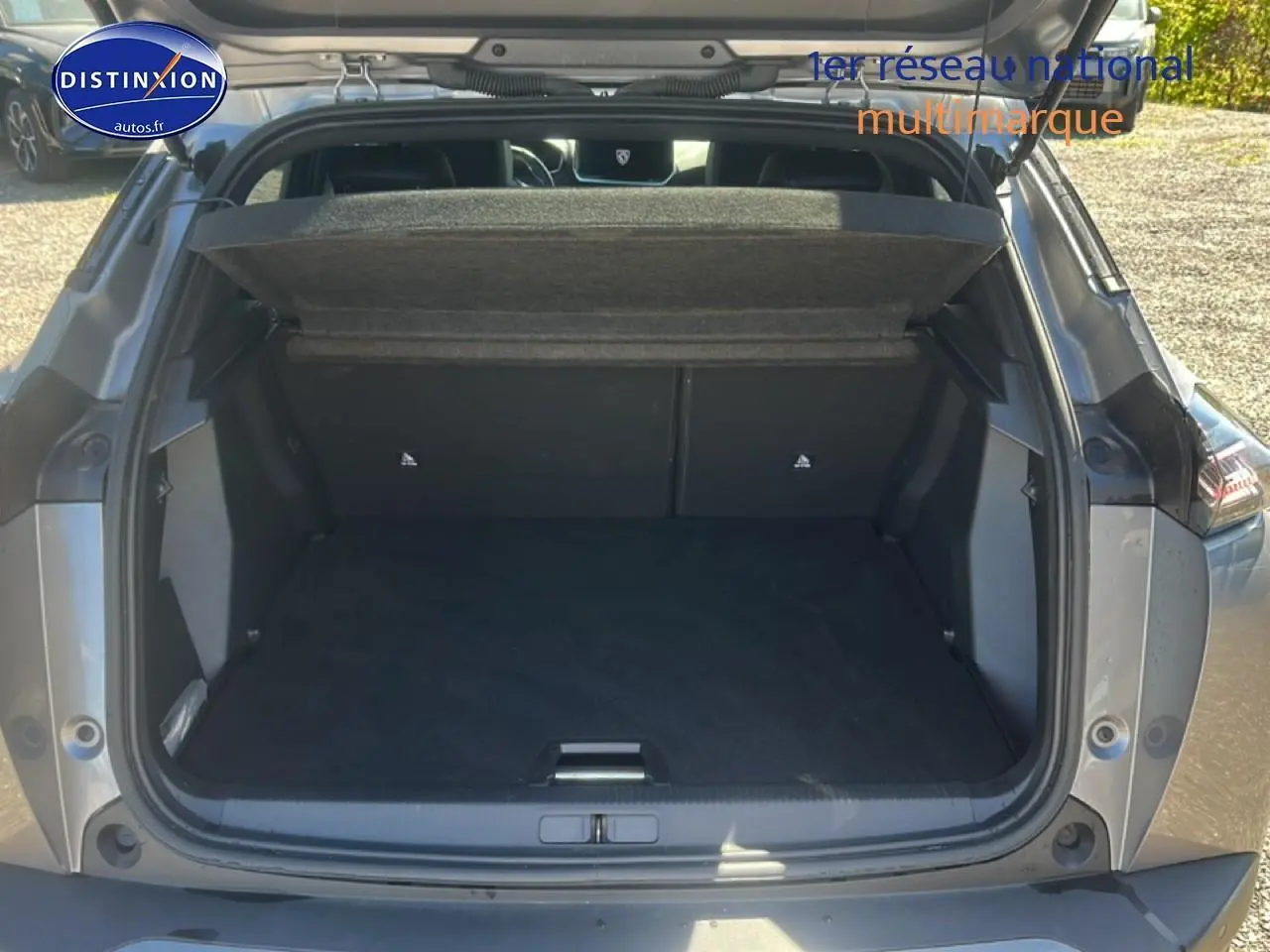 Coffre ouvert vu de l'arrière d'un Peugeot 2008 gris artense, montrant l'espace de chargement vide.