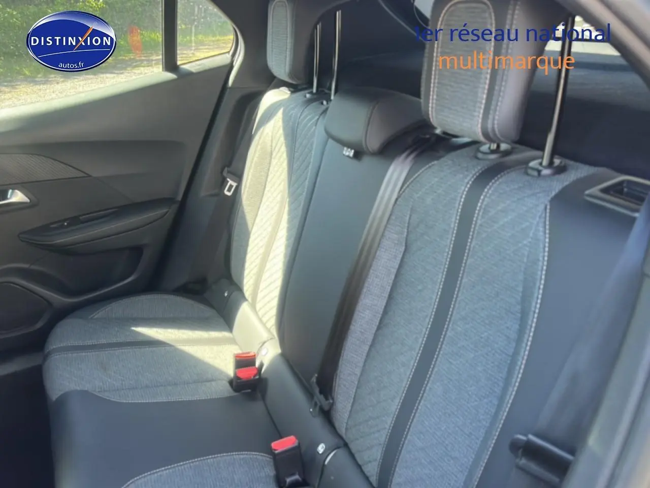 Vue intérieure sur la banquette arrière du Peugeot 2008 1.2 100 allure avec tissu gris et ceintures visibles.
