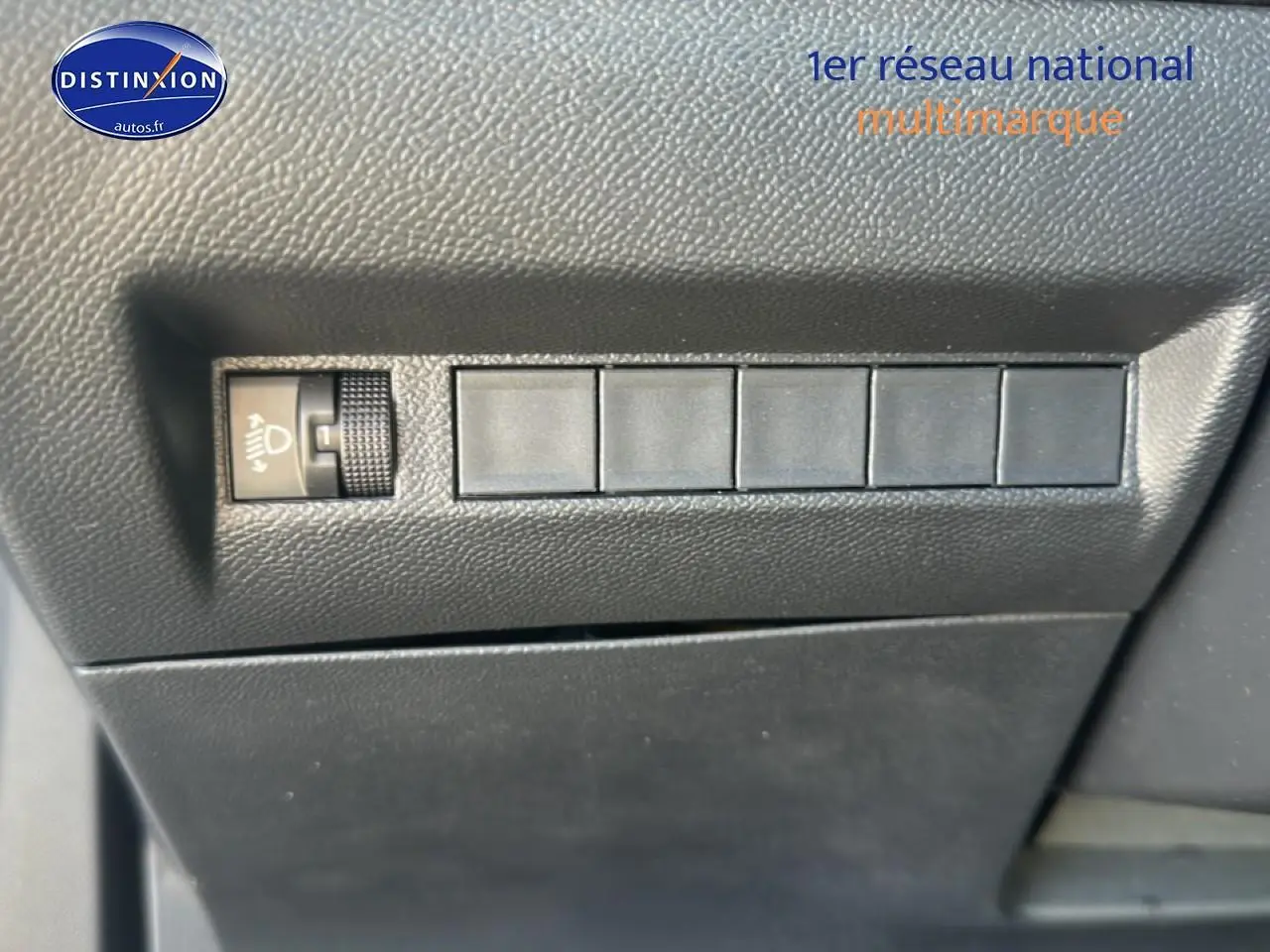 Détail intérieur montrant les commandes de réglage des phares sur la Peugeot 2008 gris artense, version 2025.