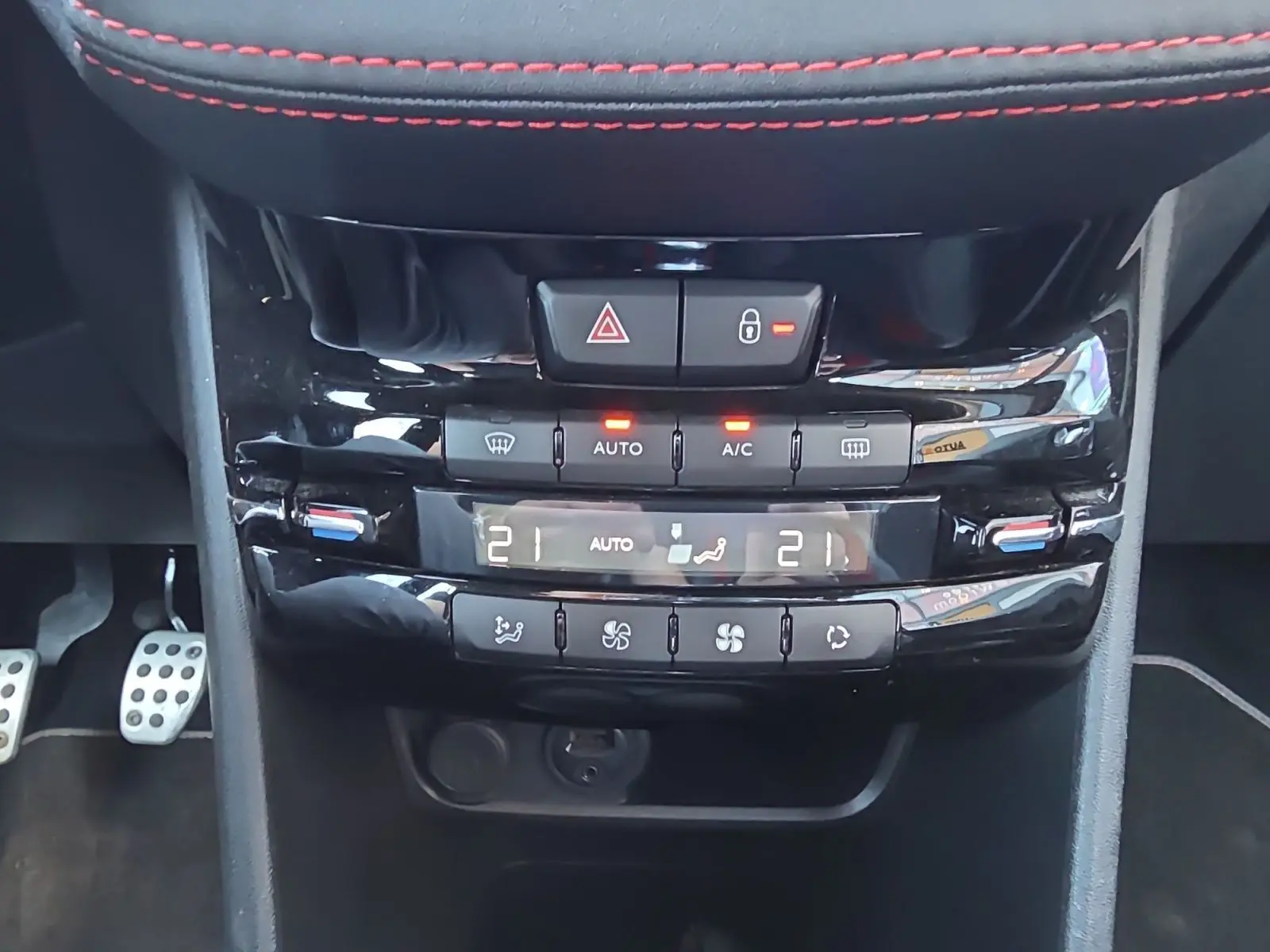 Vue rapprochée de la console centrale noire de la Peugeot 208 GTI 2015, avec climatisation automatique et commandes tactiles.
