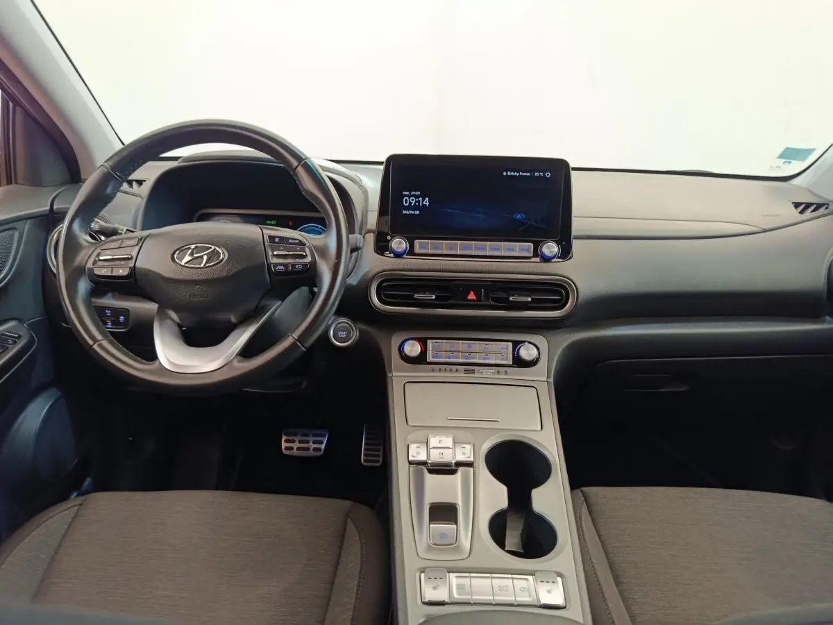 Intérieur de la Hyundai Kona électrique 2023, vue frontale du tableau de bord avec écran tactile et volant cuir noir.