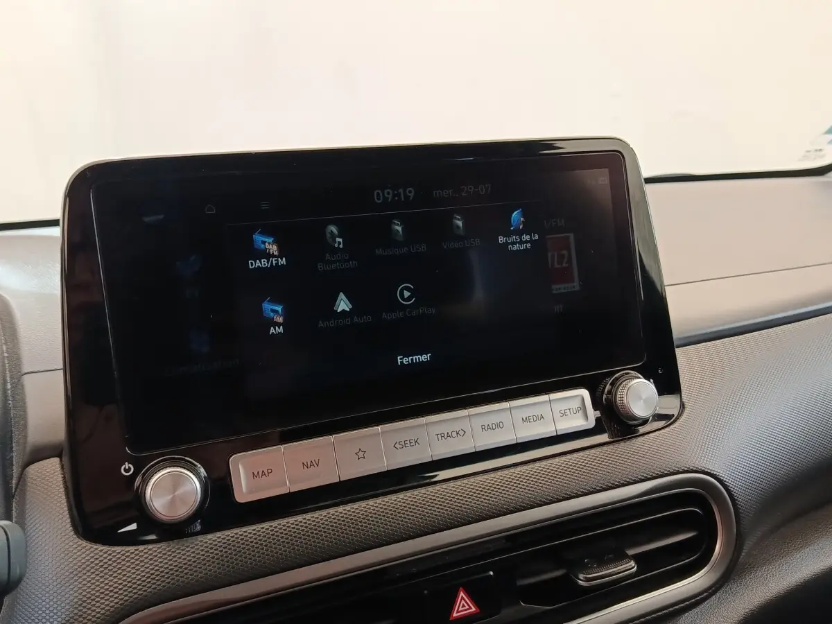 Écran tactile central noir affichant les options multimédias dans l’habitacle d’une Hyundai Kona électrique 2023.