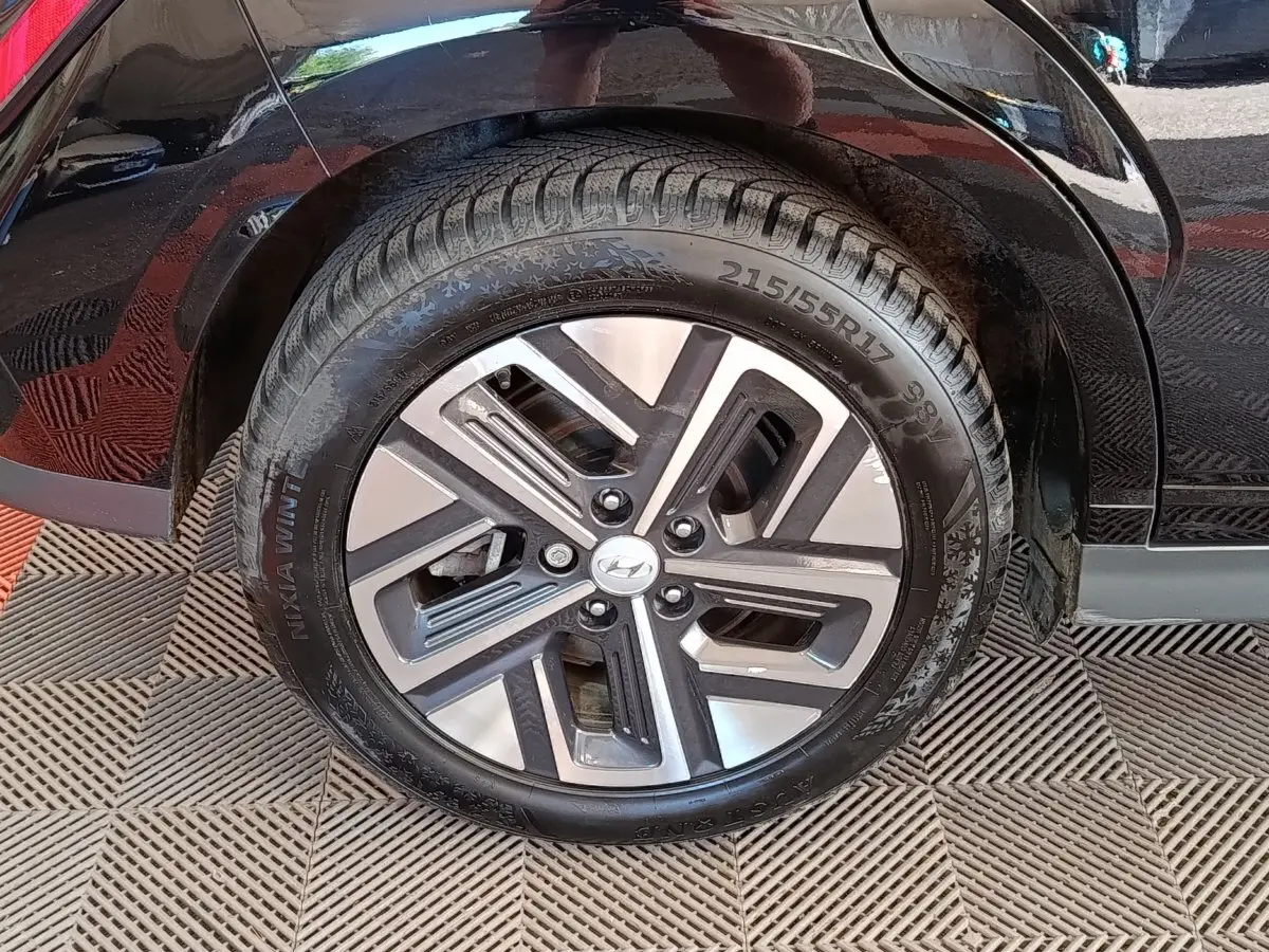 Gros plan sur la roue arrière droite du Hyundai Kona électrique noir 2023 avec jante alliage distinctive.
