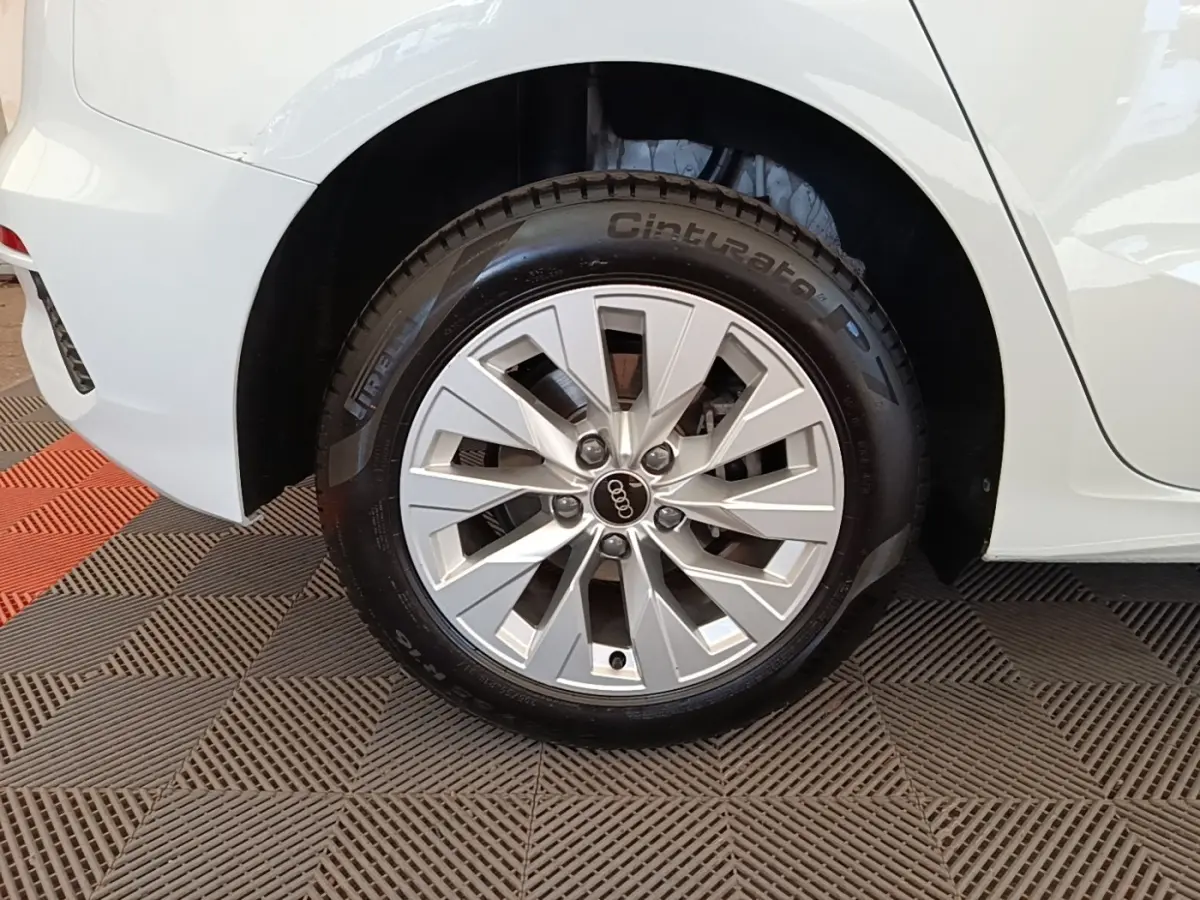 Gros plan sur la roue arrière droite blanche d’une Audi A3 40 TFSI e 204 S Tronic SB avec jante argentée en étoile.