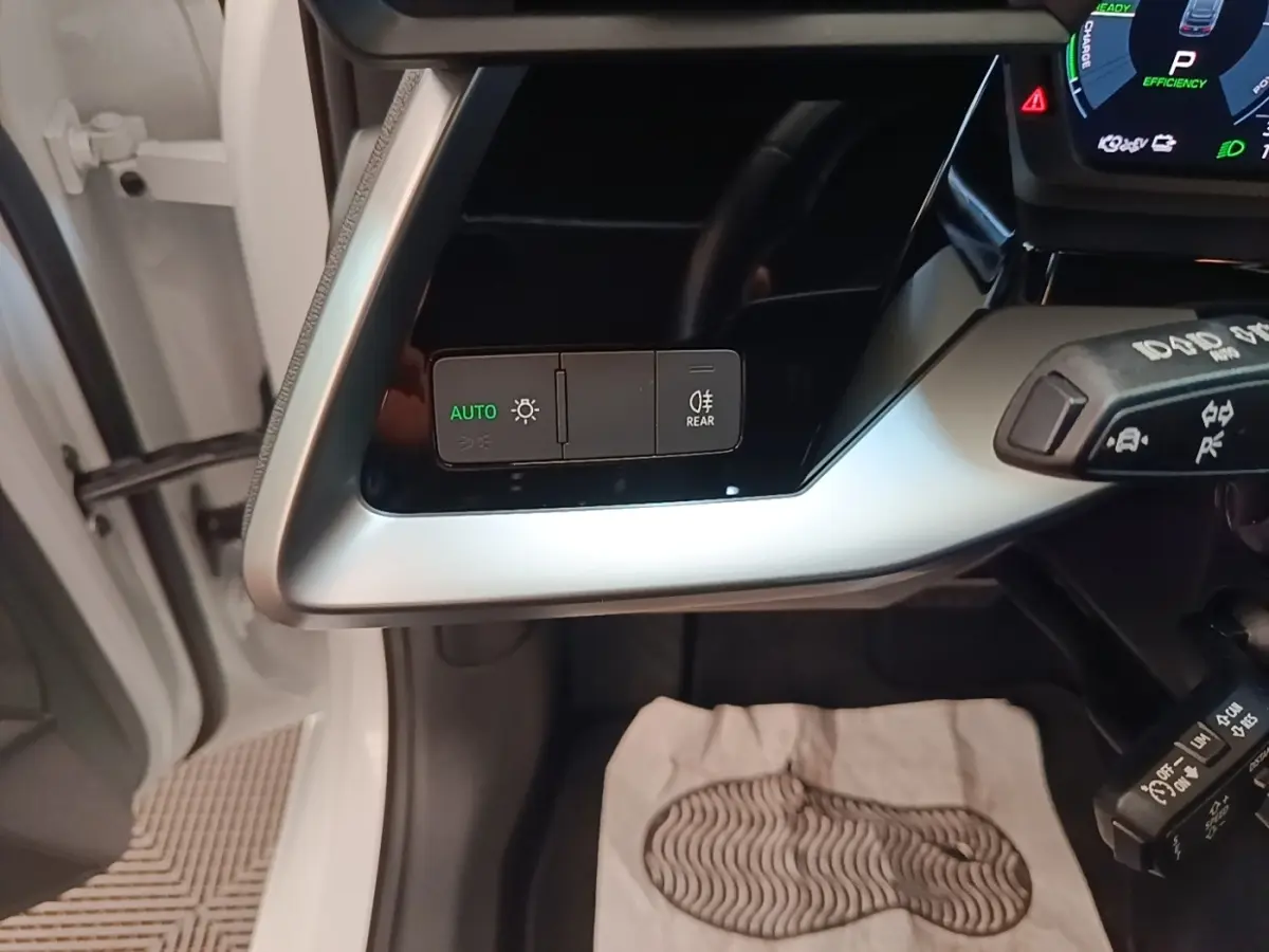 Vue intérieure côté gauche du tableau de bord de l'Audi A3 blanc, avec commandes d’éclairage et levier multifonctions visibles.