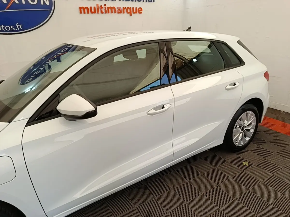 Audi A3 blanc vue de profil côté gauche, mettant en valeur la silhouette compacte et les détails des portes.