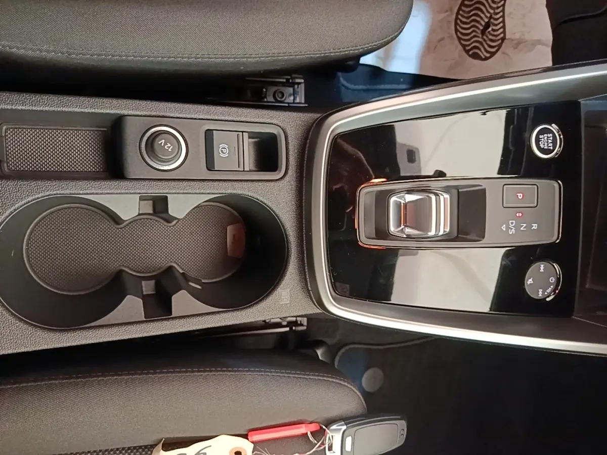 Vue plongeante sur la console centrale noire de l'Audi A3 40 TFSI e avec sélecteur de vitesse et porte-gobelets.