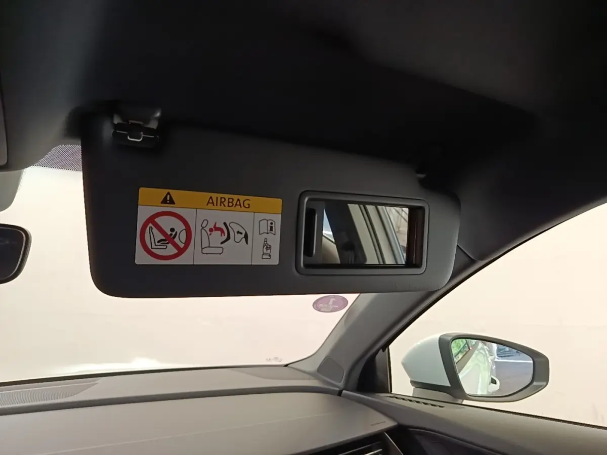 Vue intérieure côté passager de l'Audi A3 blanc, avec pare-soleil et miroir de courtoisie ouvert.