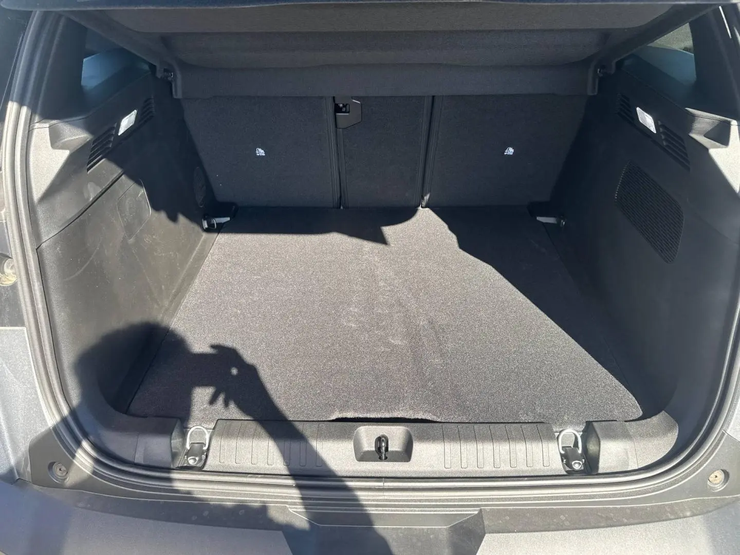 Coffre ouvert vu de l'arrière d'un Jeep Compass 2026 Yosemite avec toit noir, espace de chargement vide et tapis noir.