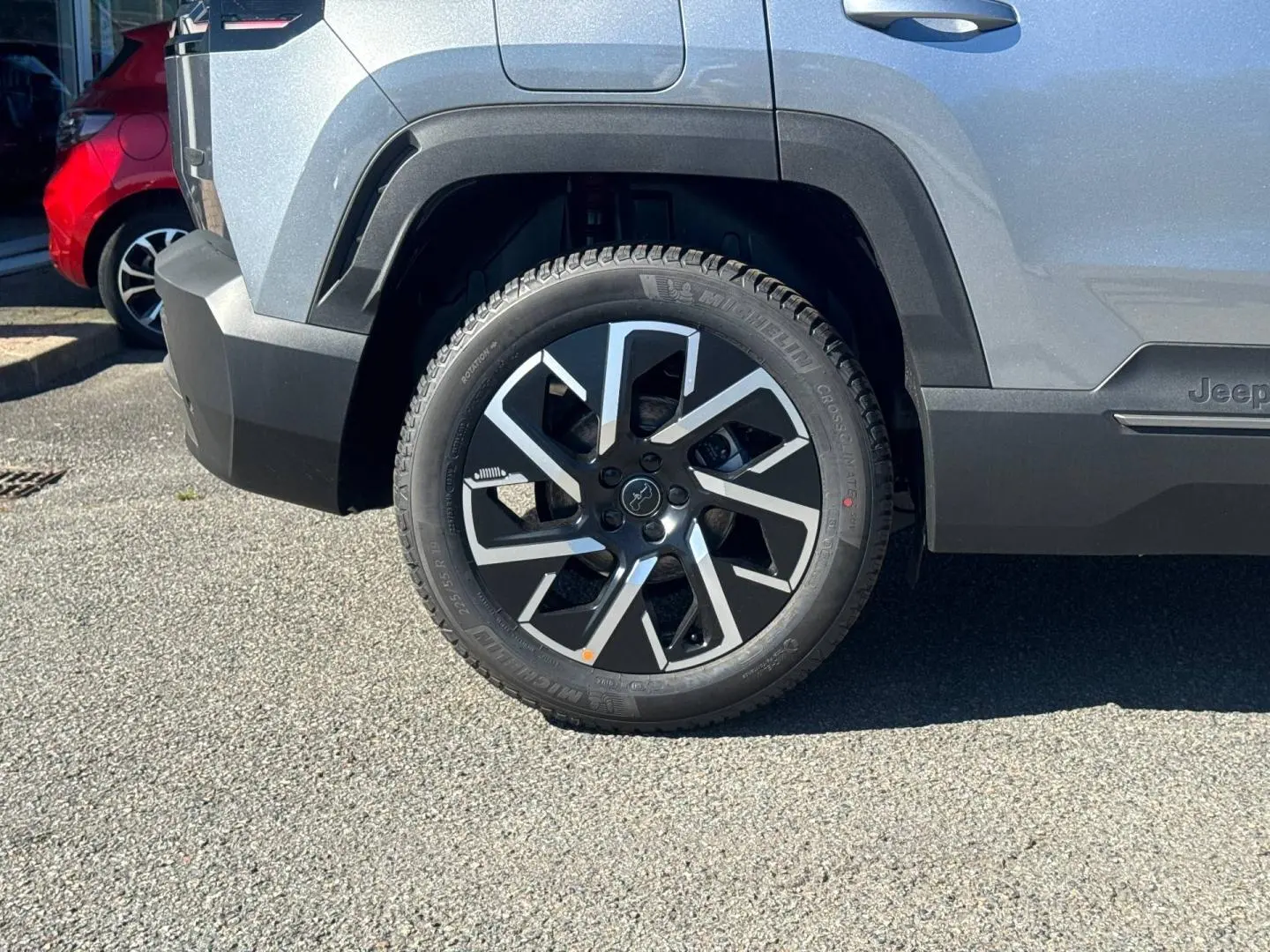 Gros plan sur la roue arrière droite du Jeep Compass Yosemite gris avec jante alu noire et grise, détails du pneu Michelin visibles.