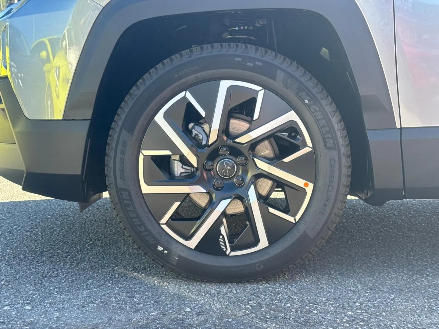 Gros plan sur la roue avant gauche du Jeep Compass 2026 Yosemite avec jante alu bicolore et logo Jeep central.