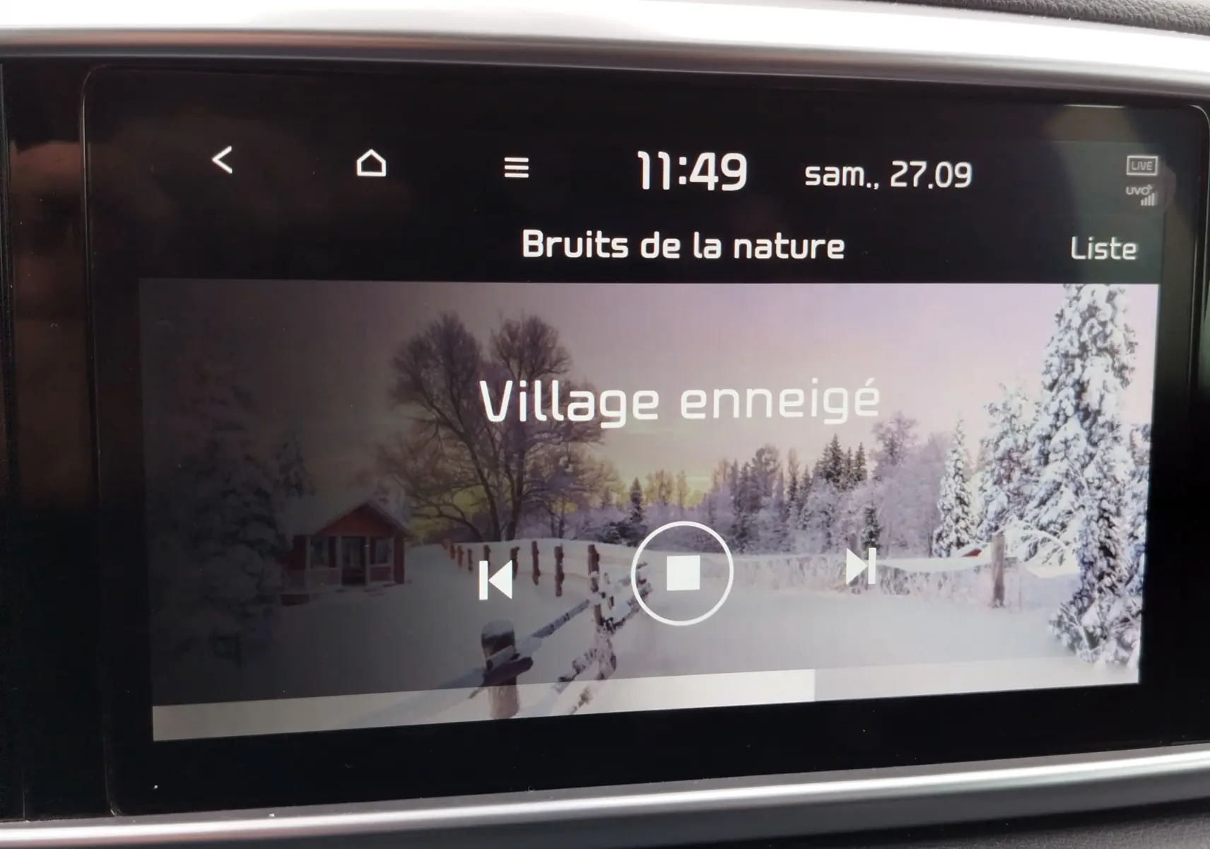 Écran tactile central du Kia Sportage 2022 affichant une ambiance sonore "Village enneigé" dans un cadre intérieur gris.