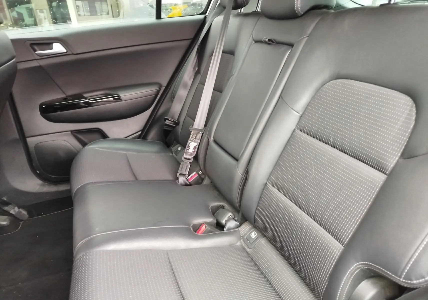 Vue latérale des sièges arrière en cuir noir et tissu gris du Kia Sportage 2022, version Black Edition.