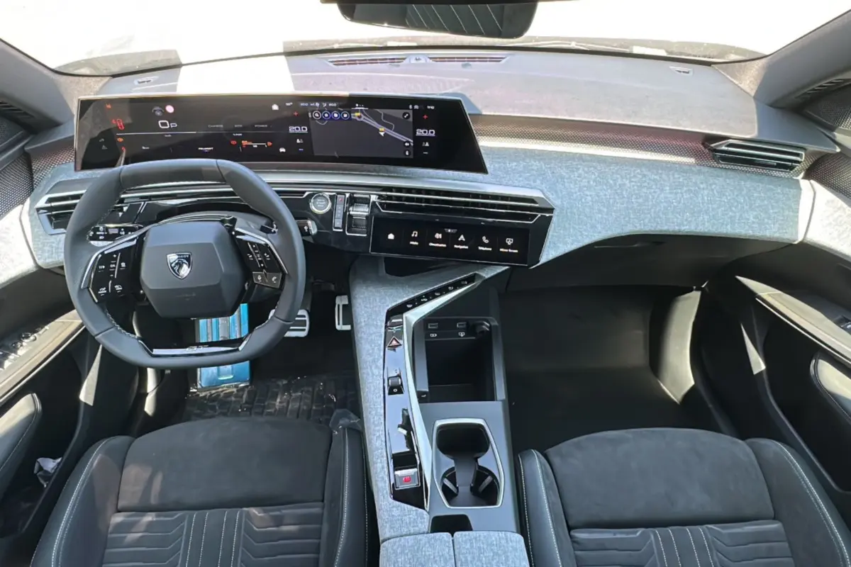 Vue intérieure du tableau de bord et volant du Peugeot 3008 Hybrid 2025 avec finition Alcantara gris et écrans numériques larges.