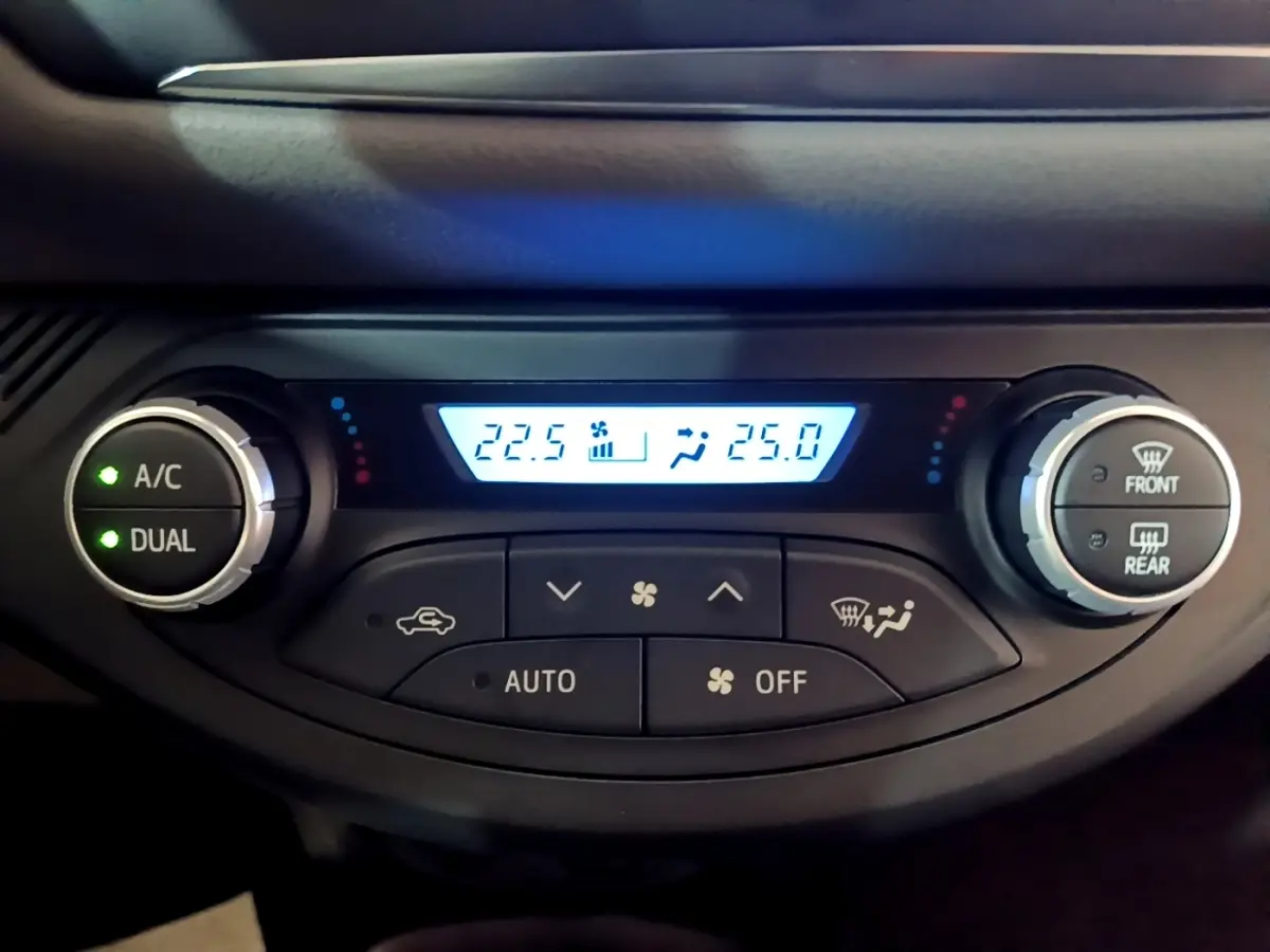 Détail de la console de climatisation digitale bi-zone de la Toyota Yaris blanche, affichage des températures à 22,5°C et 25°C.