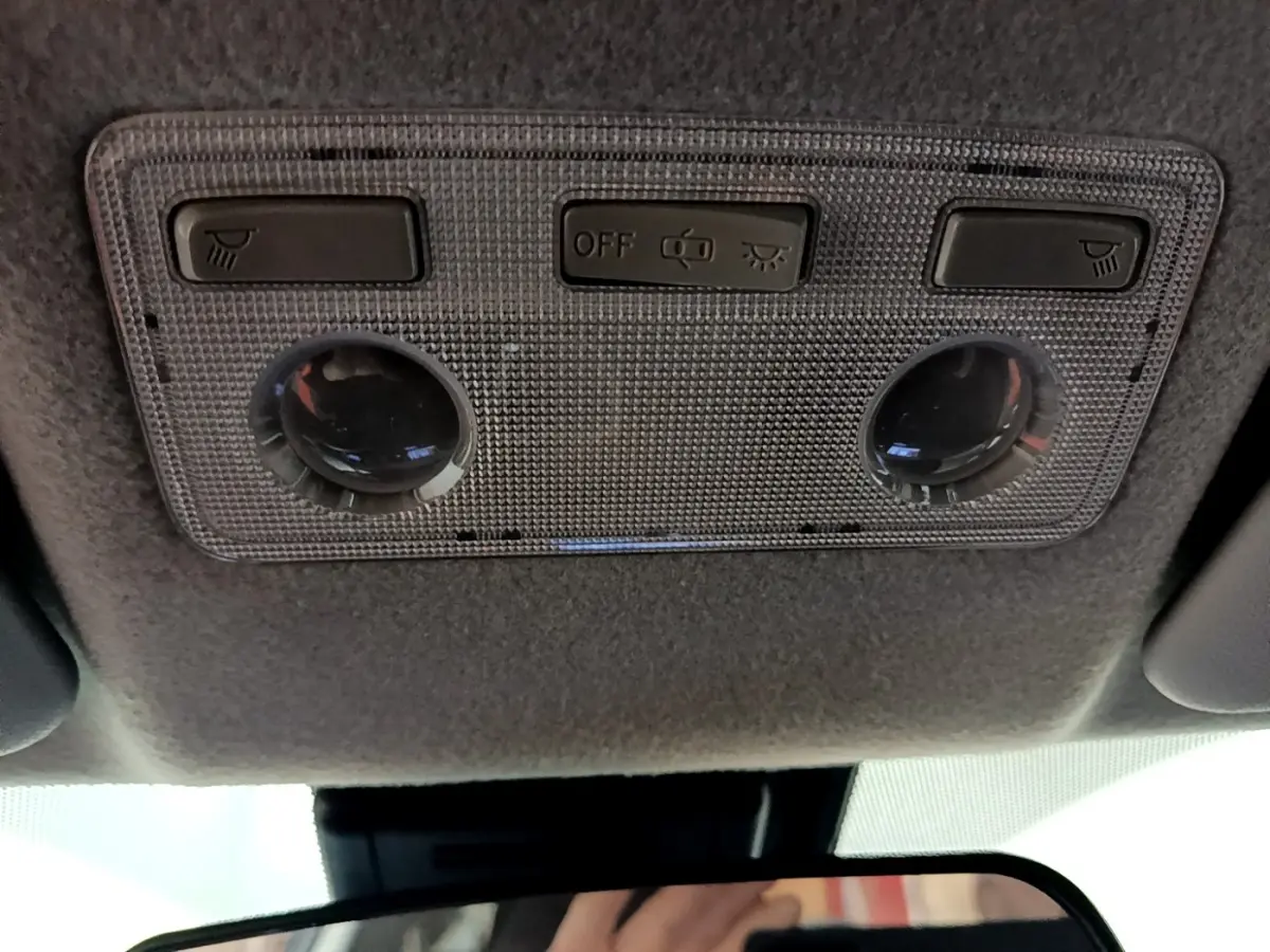 Plafonnier intérieur avec boutons d’éclairage et détecteur, vue en contre-plongée dans une Toyota Yaris blanche 2019.