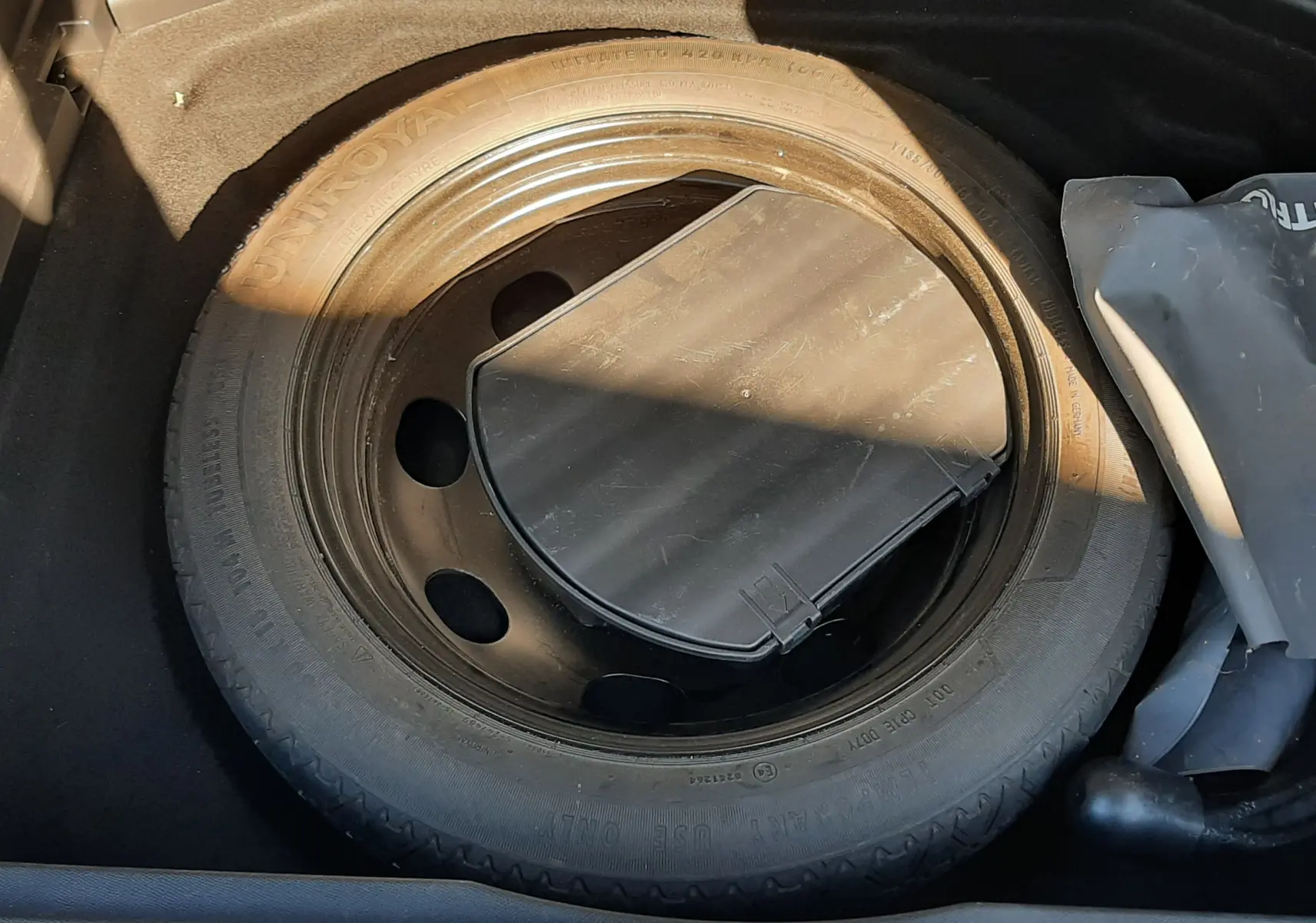 Vue rapprochée de la roue de secours noire dans le coffre du Peugeot 3008 2019 version essence.