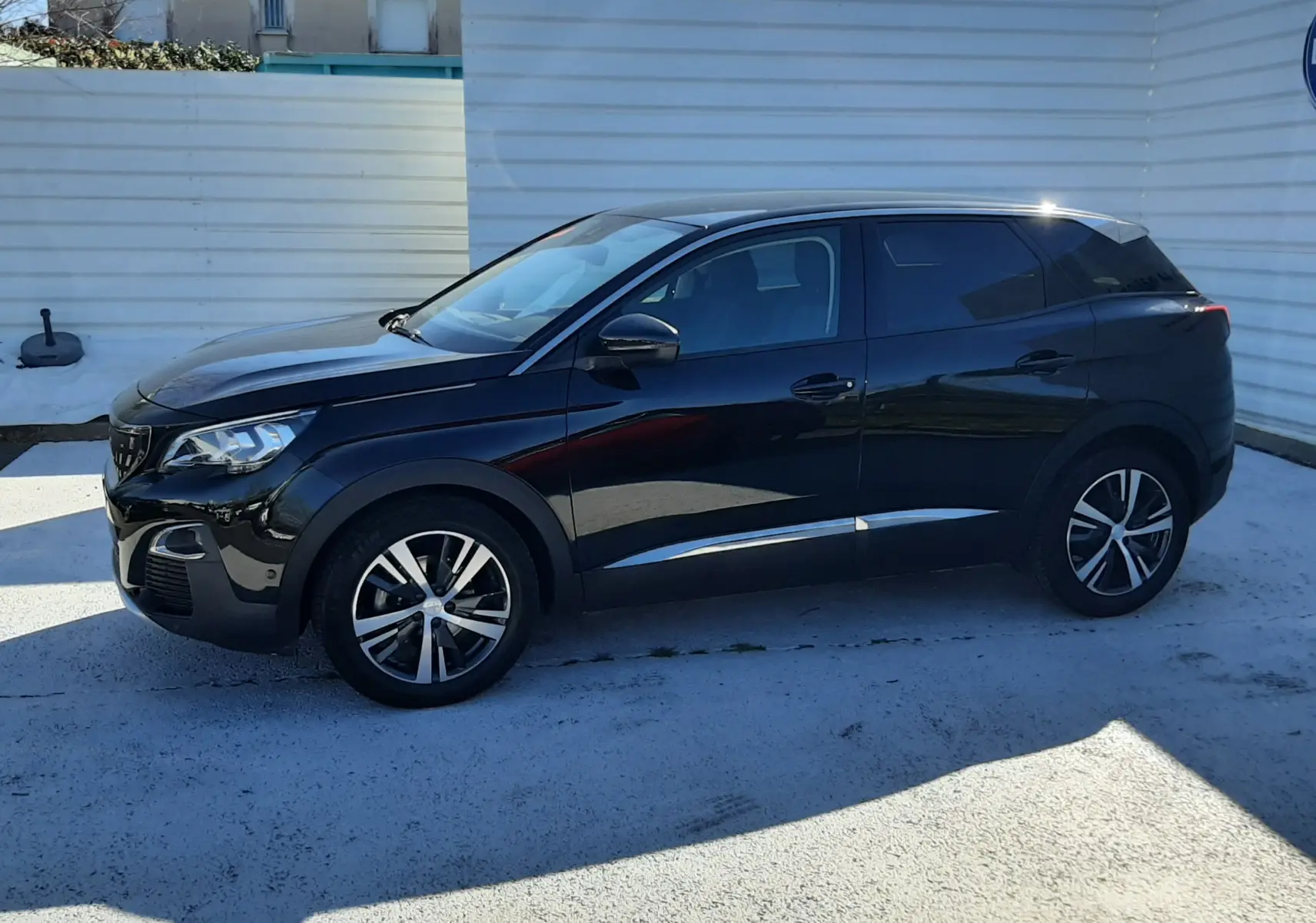 Peugeot 3008 noir vue de profil côté gauche, avec jantes alliage bicolores et vitres teintées.