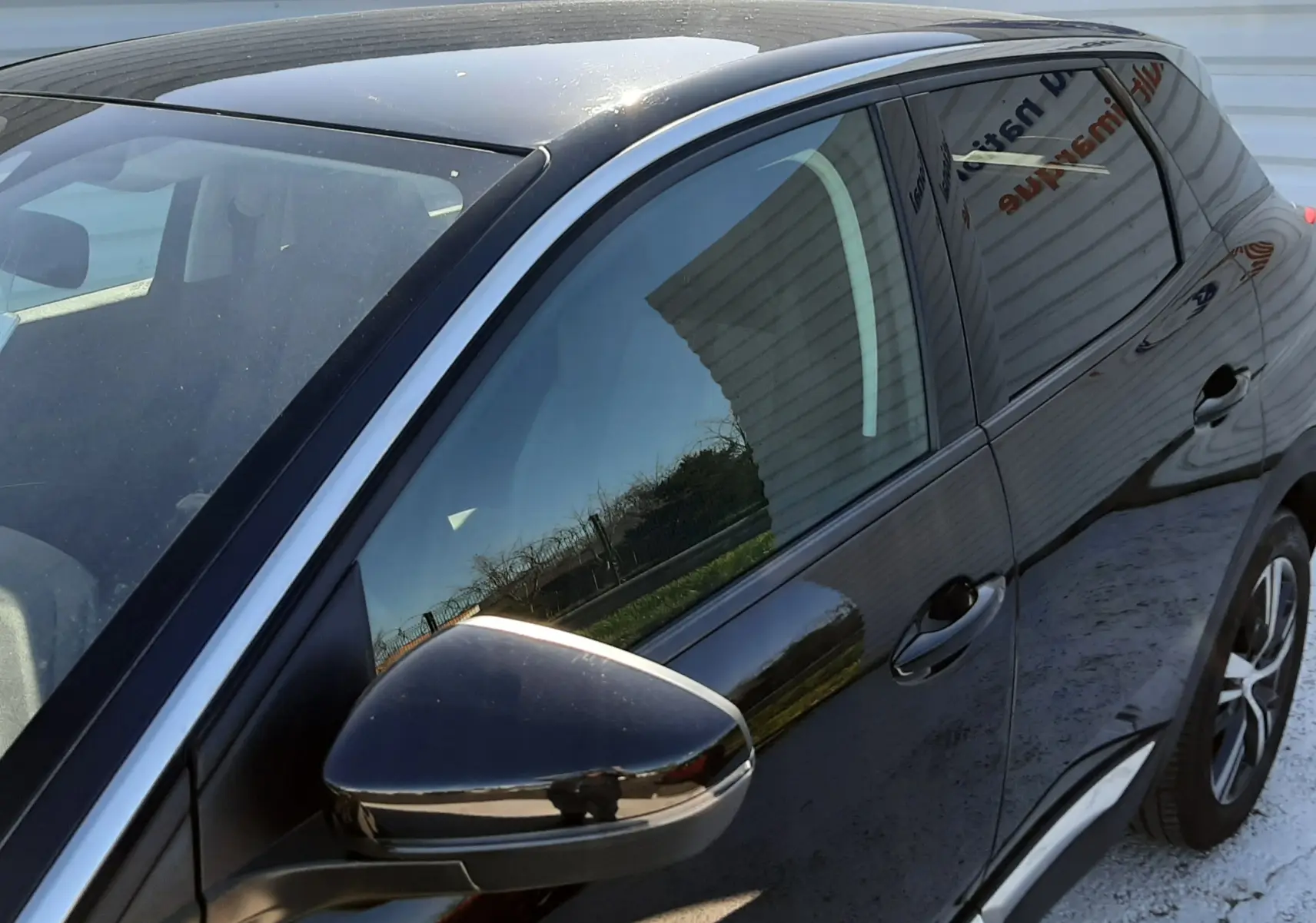 Vue de côté droit avant d'un Peugeot 3008 noir 2019, mettant en valeur la surface brillante et les rétroviseurs intégrés.