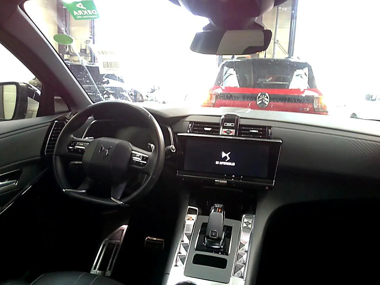 Vue intérieure avant du DS7 2025 avec tableau de bord noir, écran tactile large et volant cuir noir.