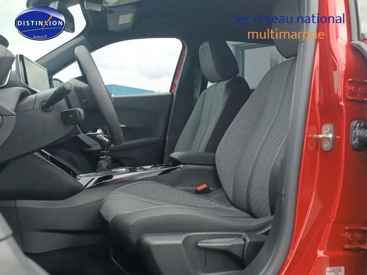 Vue intérieure côté conducteur du Peugeot 2008 rouge elixir 2025, sièges tissu casual lomsa embossé et tableau de bord moderne.