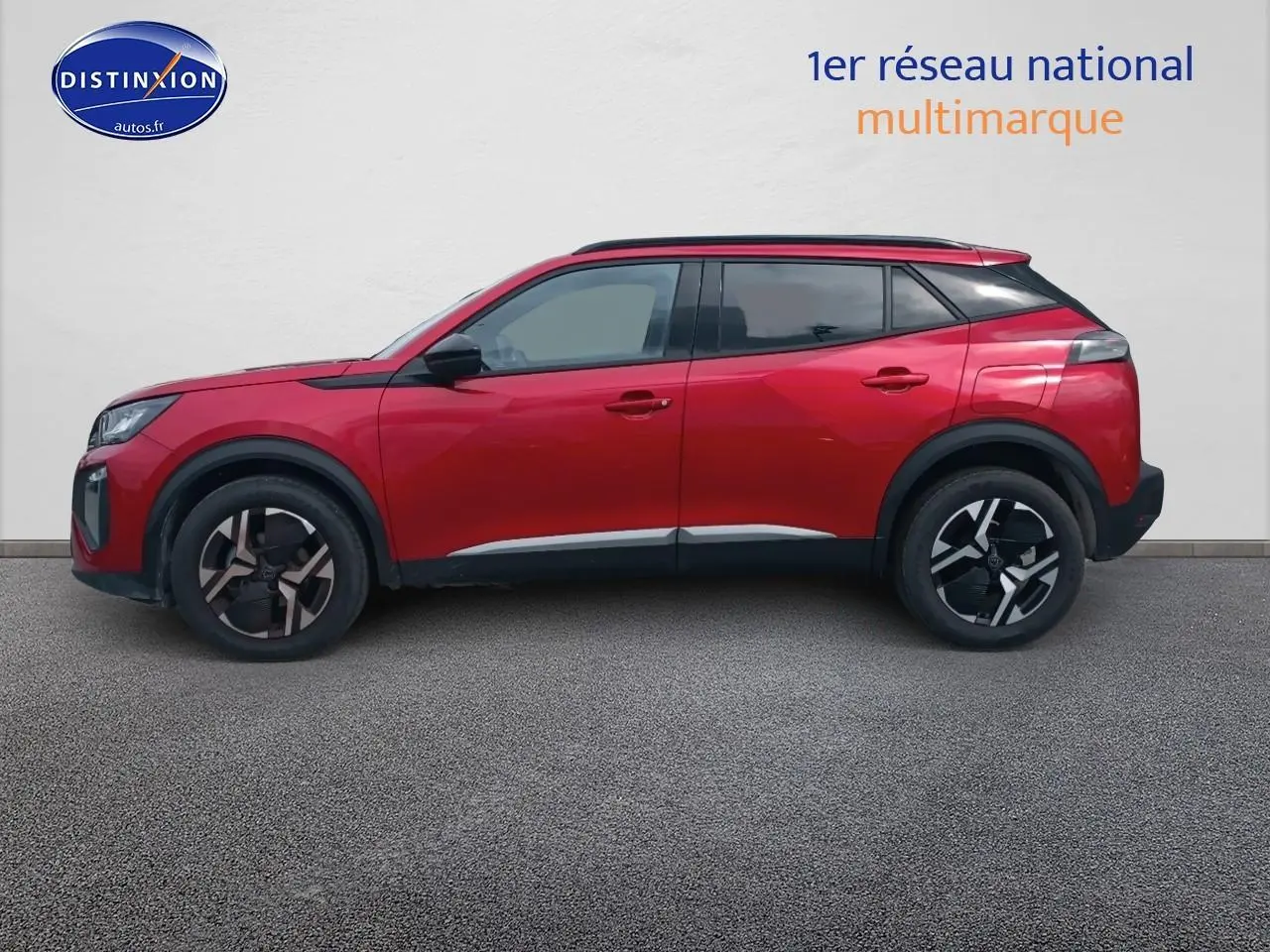 Vue de profil côté gauche d’un Peugeot 2008 rouge elixir avec jantes alliage et vitres teintées.