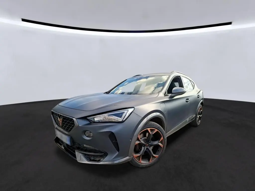Vue 3/4 avant d’un CUPRA Formentor 1.4 E-HYBRID 245 DSG6 VZ gris foncé mat avec jantes noires et accents cuivrés.