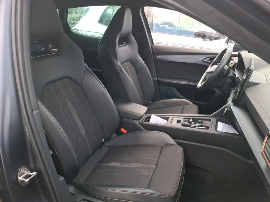 Vue intérieure côté conducteur de la CUPRA Formentor 1.4 E-HYBRID 245 DSG6 VZ 2024 avec sièges sport noirs et console centrale.