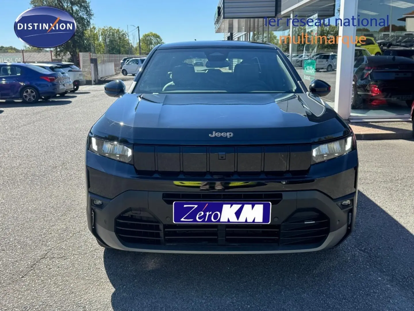 Vue frontale d'un Jeep Compass 2026 couleur Vulcano avec calandre noire et phares LED allumés.