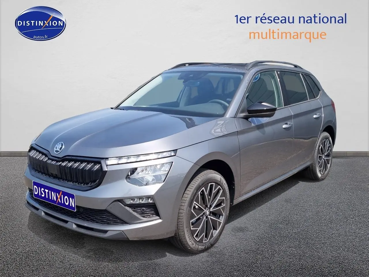Vue 3/4 avant droite d'un Skoda Kamiq gris graphite 2025 avec calandre noire et jantes alliage distinctives.