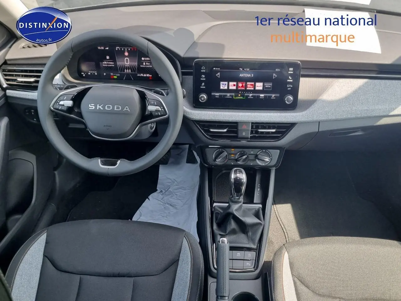 Intérieur du Skoda Kamiq 2025 en vue plongeante, tableau de bord moderne avec écran tactile et volant multifonction noir.