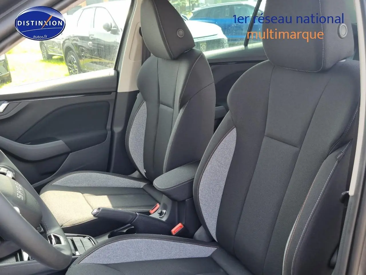 Intérieur SKODA KAMIQ 2025 montrant sièges avant bicolores gris et noir avec accoudoir central jumbo box.