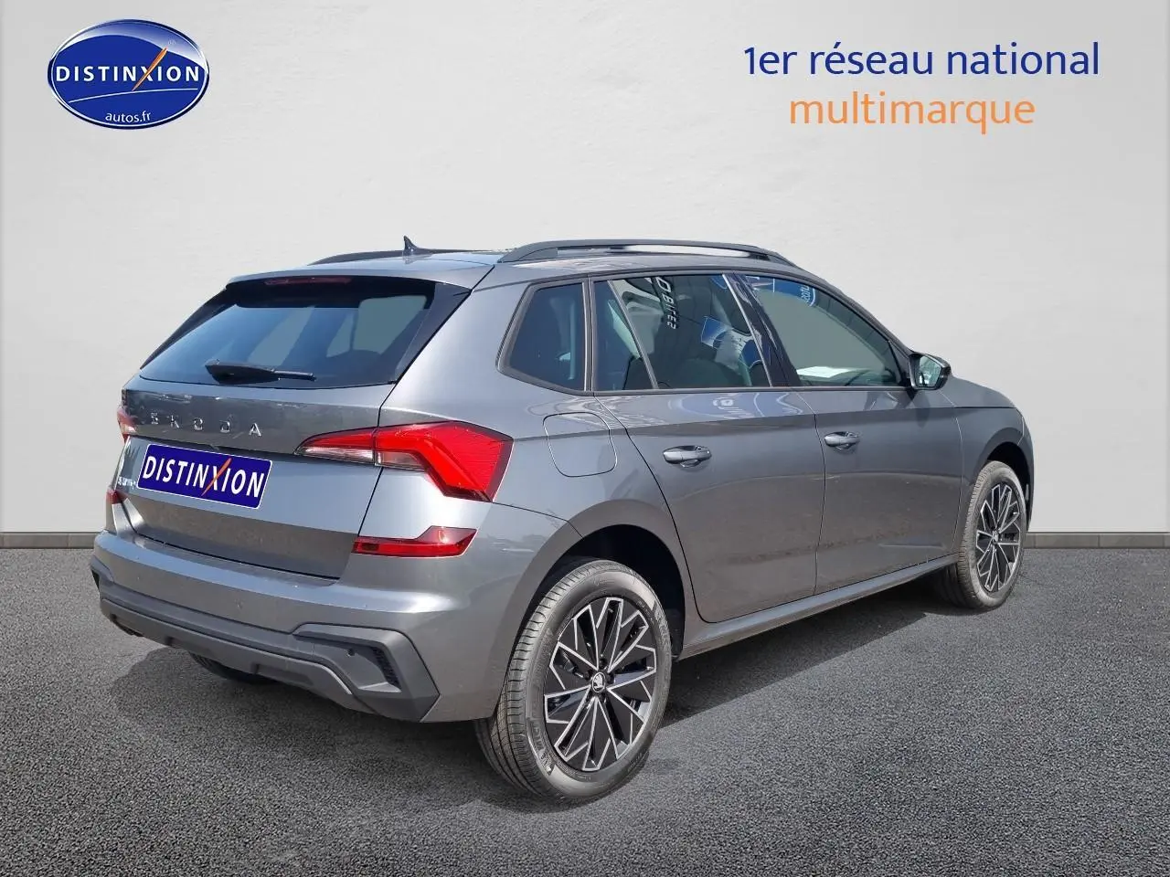 Vue 3/4 arrière droite d'un Skoda Kamiq gris graphite avec barres de toit noires et feux arrière LED.