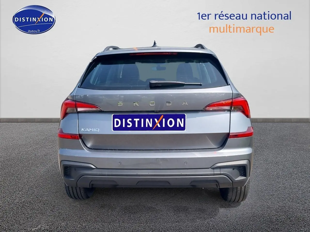 Vue arrière d'un Skoda Kamiq gris graphite 2025 avec feux LED et barres de toit noires visibles.