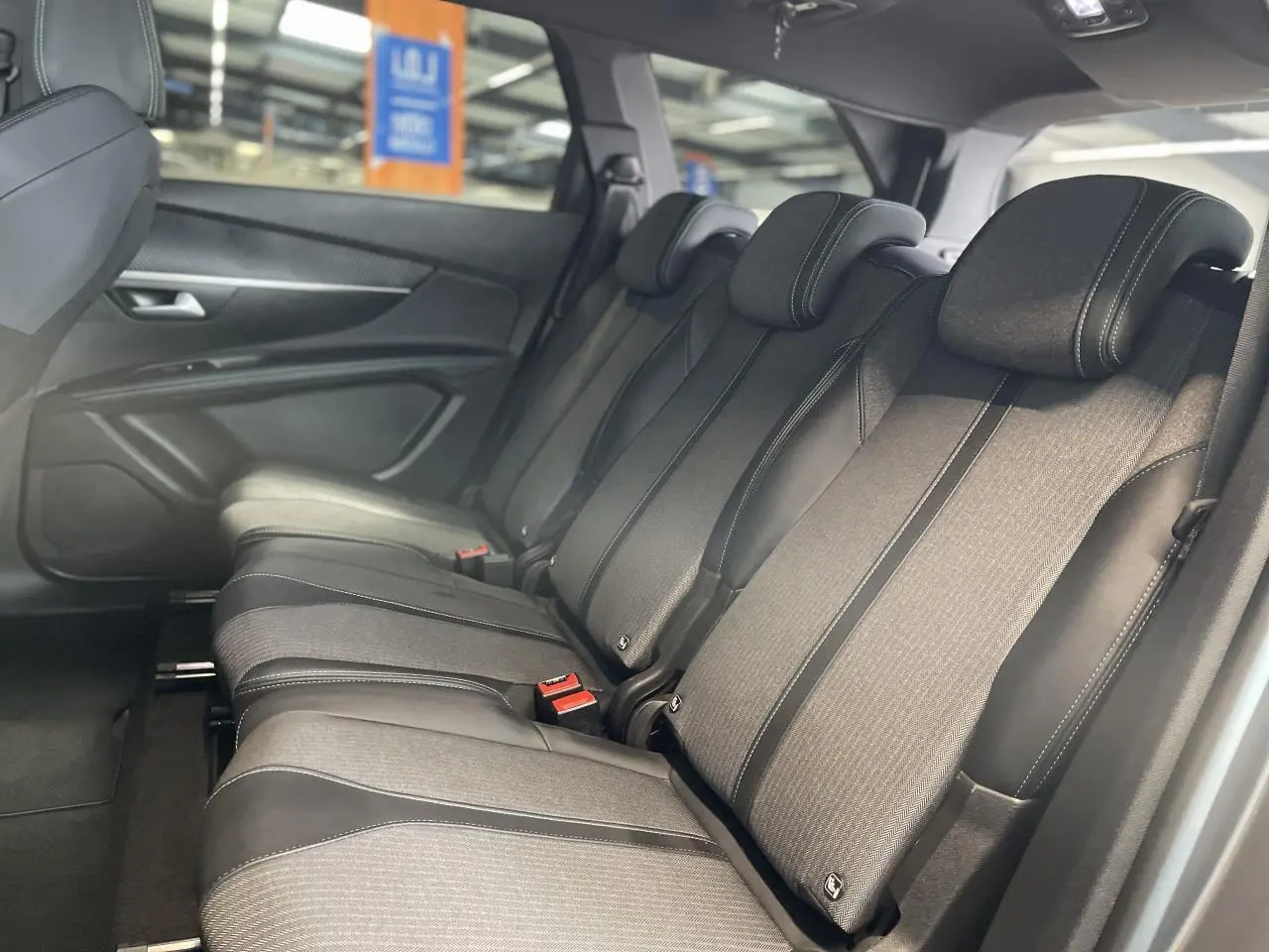 Vue latérale droite des trois sièges arrière indépendants en tissu et cuir noir du Peugeot 5008 2024 gris platinium