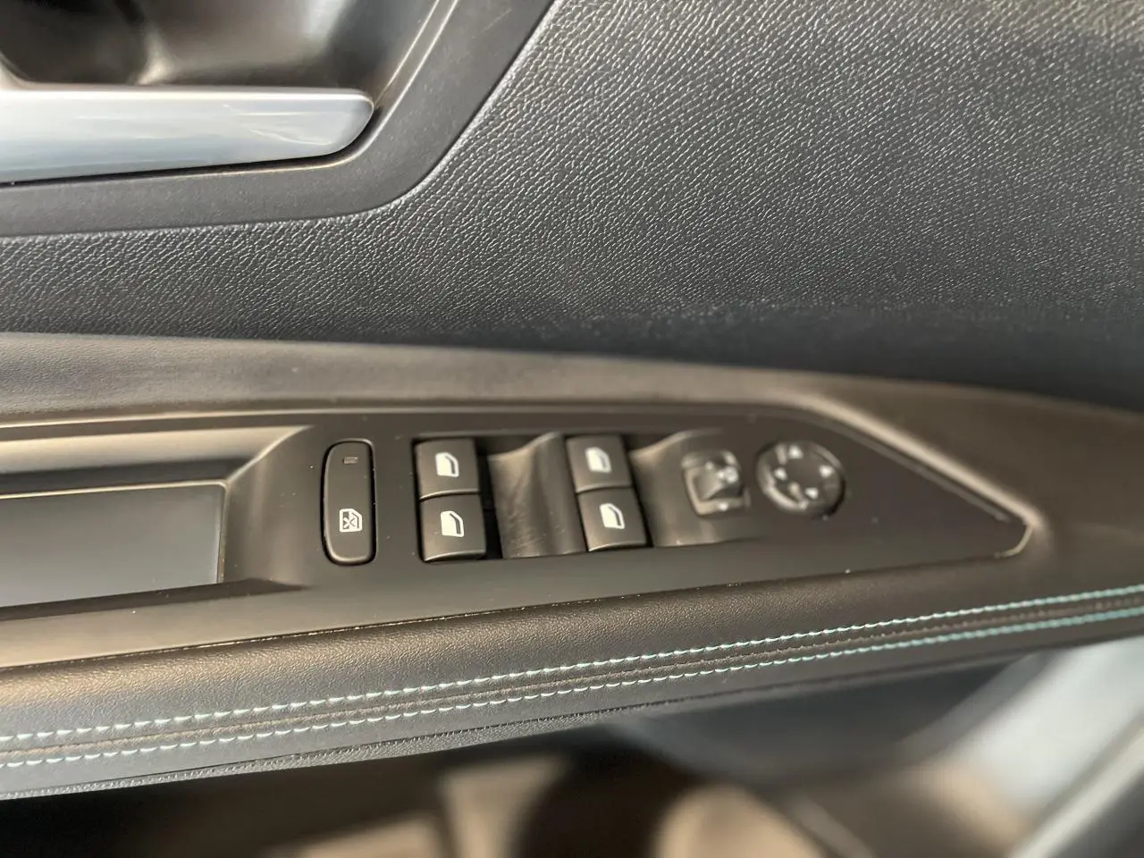 Panneau de porte côté gauche du Peugeot 5008 2024 avec commandes de vitres et réglage des rétroviseurs, surpiqûres bleues.