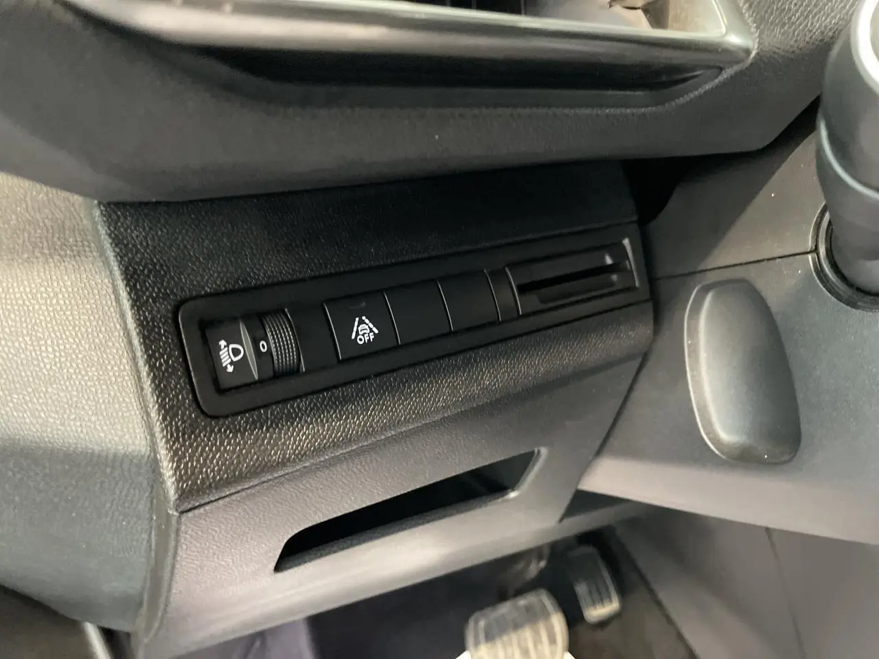 Détail des commandes d'éclairage et d'aide à la conduite côté gauche du tableau de bord du Peugeot 5008 gris platinium.